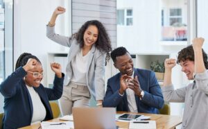 Succeeding in their mission as a team. Shot of a group of businesspeople cheering in an office.